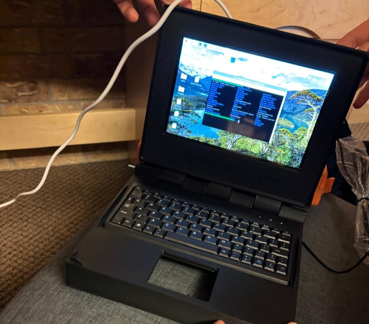 A Raspberry Pi cyberdeck with a keyboard, screen, and antennas on a workbench